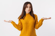 Image of adult woman wearing sweater hesitating and throwing up hands