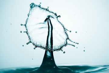 Water splash crown. Drop collision on blue background