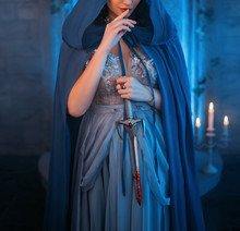 Luxury Beauty Elf Queen Medieval Royal Creative Clothes Holds Gothic Dagger Stained Blood. Blue Silk Dress, Cloak Hood Silver Tiara. Backdrop Old Retro Castle Room. Dangerous Strong Power Conspirator