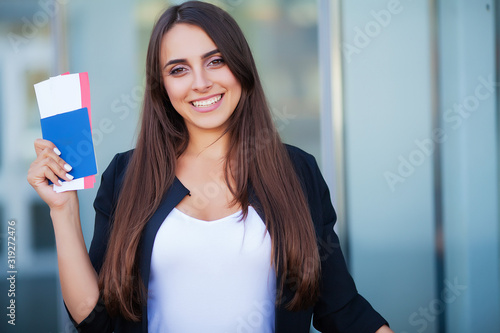 Fotomural Woman holding two air ticket in abroad passport near airport