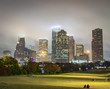 Houston Texas city skyline and green field on a cloudy foggy evening	