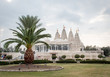 White Houston Hindu temple and palm tree on a cloudy day