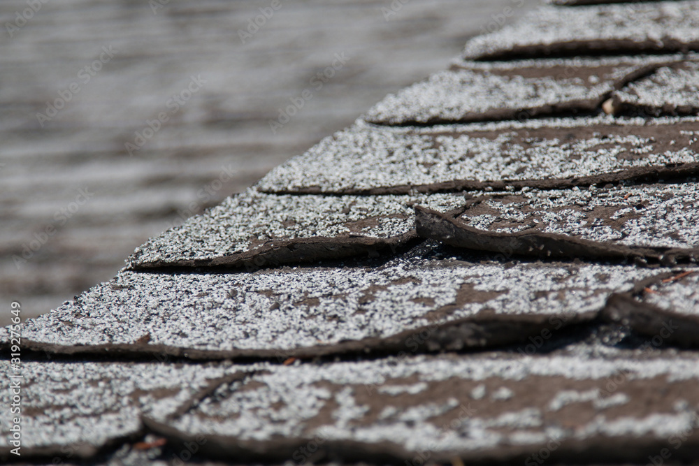 Old worn out asphalt shingles on the roof of a residential home. - obrazy, fototapety, plakaty 