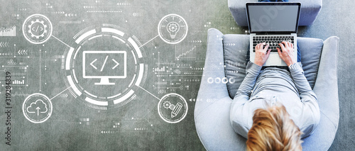 Cuadros en Lienzo Web development concept with man using a laptop in a modern gray chair