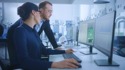 Wall Mural - Modern Electronics Factory: Male Supervisor Talks to a Female Electrical Engineer who Works on Computer with CAD Software. Developing PCB, Microchips, Semiconductors and Telecommunications Equipment