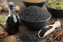 Black Cumin Or Roman Coriander Seeds And Black Caraway Oil Bottles, Aromatic Spices On Table: Cardamom, Anise, Cloves, Cinnamon,  Turmeric. Ingredients For Cooking. Ayurveda Treatments.