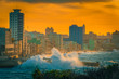 the havana malecon in the colorful orange sunset light with big waves, cuba