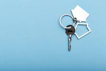 House Keys With Trinket On Color Background, Top View With Copy Space. House Key On Blue Background. Minimal Flat Lay Style With Place For Text.