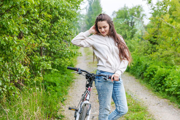 Wall Mural - Young woman riding bicycle in summer city park outdoors. Active people. Hipster girl relax and rider bike. Cycling to work at summer day. Bicycle and ecology lifestyle concept