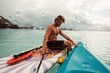 © Amber - Man sits with kayak on tropical lagoon during a stormy day at sea