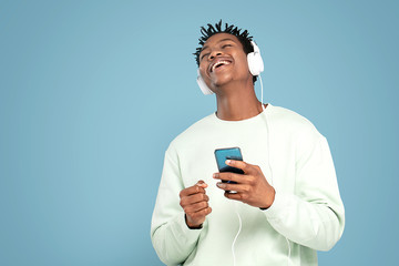 Happy african man listening to music.