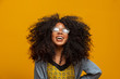 © Nexa - Beauty portrait of african american with glasses and afro hairstyle on a yellow background. Brazilian young woman.