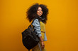 © Brastock Images - Female student in campus with books in her arms. Yellow background.