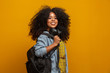 © Brastock Images - Female student in campus with books in her arms. Yellow background.