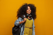 © Brastock Images - Female student in campus with books in her arms. Yellow background.