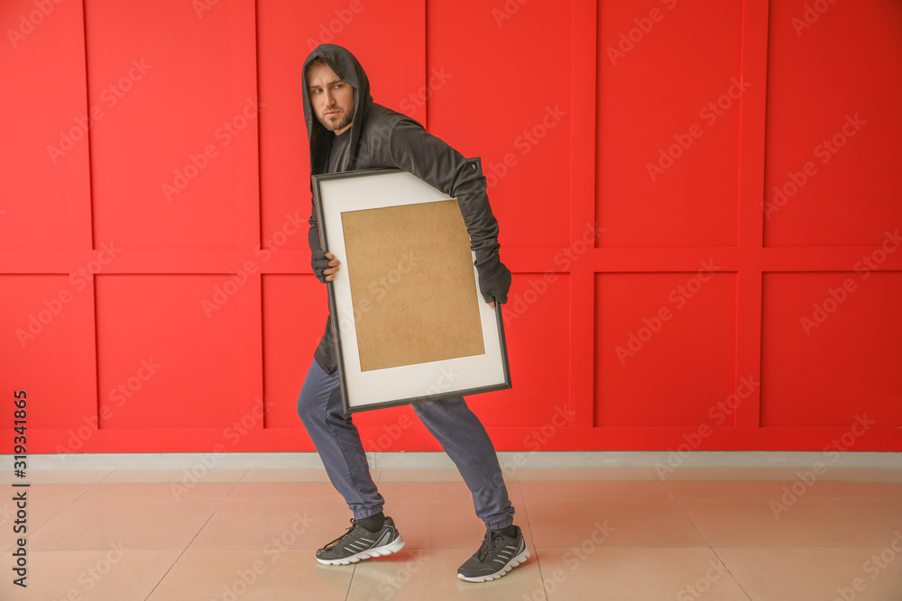 Thief stealing picture from art gallery