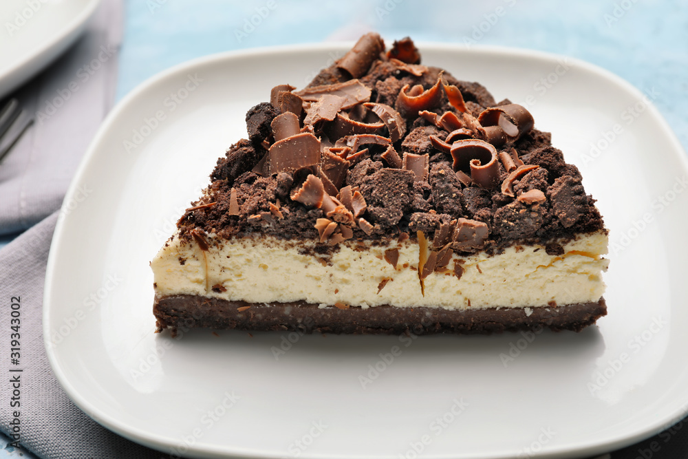 Plate with piece of tasty chocolate cheesecake on table