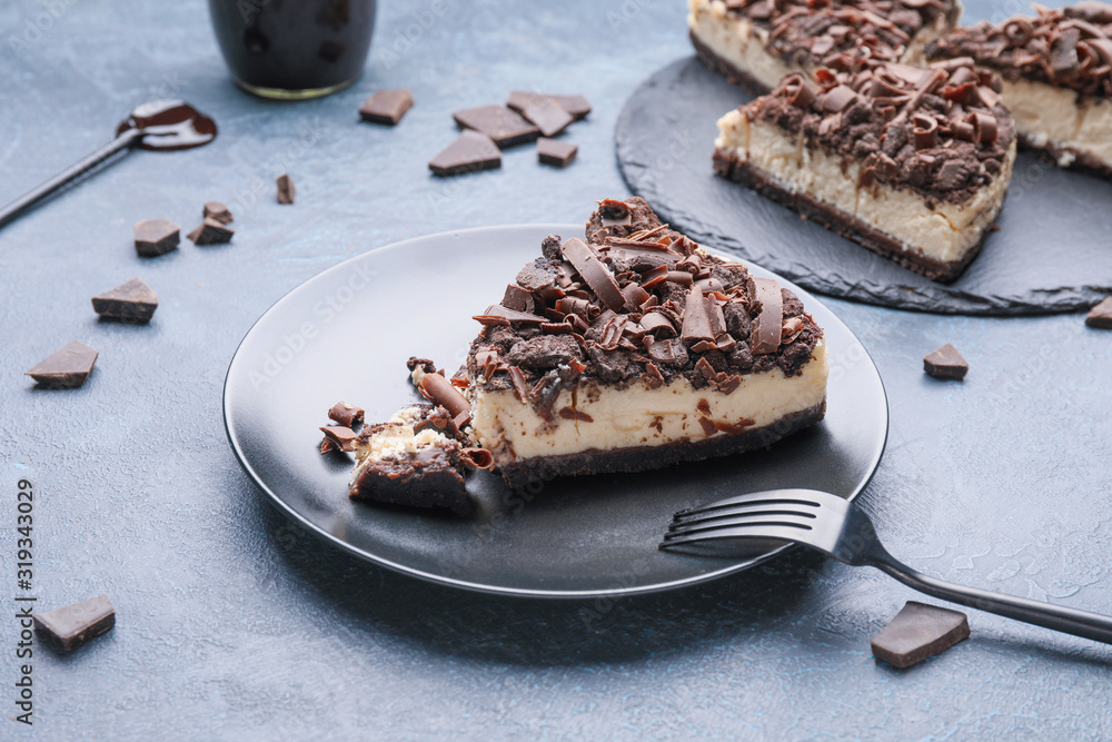 Plate with piece of tasty chocolate cheesecake on table