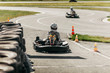 © Aleksandra - a man in a gray sweatshirt and jeans, in a white helmet drives a black kart with number 7 on an asphalt track