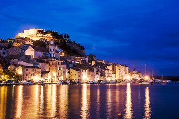 Wall Mural - Illuminated harbor in Sibenik, Croatia. Sibenik at night, view on St. Michael's Fortress, Croatia. View of city in Adriatic coast of Croatia during blue hour. City illuminated at the evening.