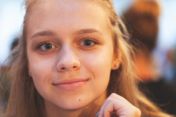 Beautiful blond European teenage girl smiles at the camera