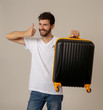 © SB Arts Media - Stylish handsome man showing suitcase. Advertising storage space for travelers and tourism image.
