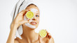 © Olesia - Cosmetology, skin care, face treatment, spa and natural beauty concept. Woman with facial mask holds lemons.