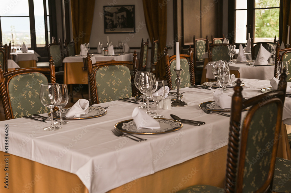Interior of a classic restaurant in an old castle. Traveling in Europe. Served tables and antiquity - obrazy, fototapety, plakaty 