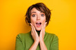 © deagreez - OMG. Closeup photo of funny lady listen positive good news open mouth arms on cheeks wear casual green turtleneck warm sweater isolated yellow color background