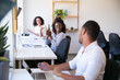 © Mangostar - Cheerful colleagues communicating at workplace. Smiling workers chatting at workplace. Communication and teamwork concept