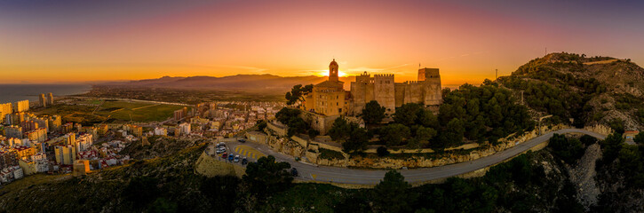 Wall Mural - Cullera castle and church on a hilltop overlooking the popular summer resort town and the Mediterranean  in Spain