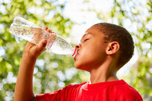 African Boy Drinks From Water Bottle