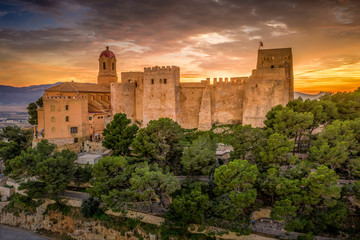 Aerial sunset view of Cullera castle and Sanctuary of the Virgen del Castillo above the popular summer resort vacation beach town near Valencia Spain