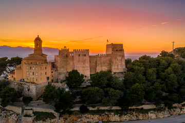 Wall Mural - Aerial sunset view of Cullera castle and Sanctuary of the Virgen del Castillo above the popular summer resort vacation beach town near Valencia Spain