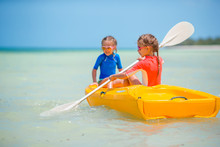 Little Adorable Girls Enjoying Kayaking On Yellow Kayak