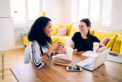 Cuadros en Lienzo Active black woman talking to smiling friend explaining information
