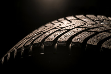 car tire with studs, macro, dark blurred background