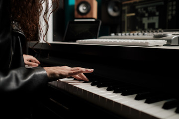 Wall Mural - Woman hands playing keyboard at the studio