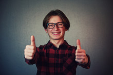 Cheerful Boy Adolescent Showing Double Thumbs Up, Positive Gesture, Great Feedback And Approval, Looking To Camera With Teeth Smile Isolated Over Grey Wall Background.