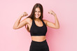 Leinwandbild Motiv Young caucasian fitness woman doing sport isolated showing strength gesture with arms, symbol of feminine power