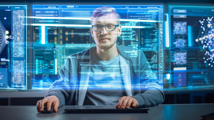 Fototapete - Portrait of Software Developer / Hacker Wearing Glasses Sitting at His Desk and Working on Futuristic Transparent Computer in Digital Identity Cyber Security Data Center. Hacking or Programming.