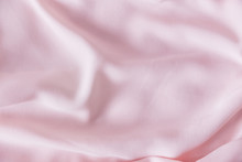 Pink Wrinkled Silk Fabric. The Pink Fabric Is Laid Out Waves. Pink Fabric Background Or Texture.
