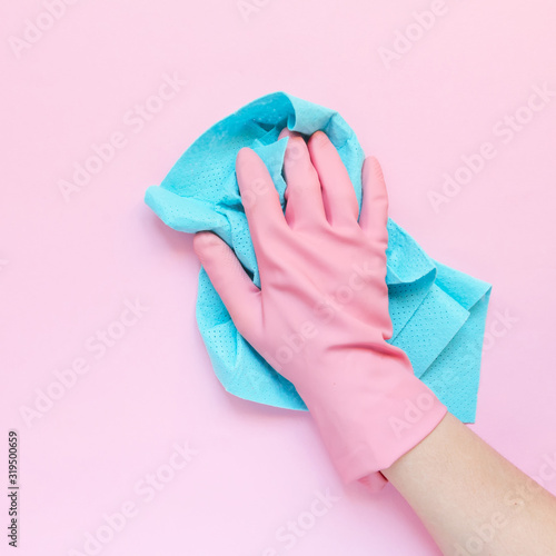 Fotomural Employee hand in rubber protective glove with micro fiber cloth wiping wall from dust