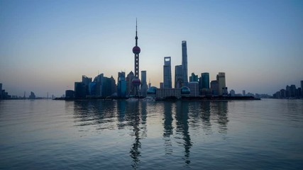 Wall Mural - Time lapse of Shanghai skyline at sunrise, reflection on Huangpu River. Shanghai, China