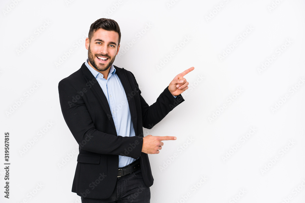 Young caucasian business man against a white background isolated excited pointing with forefingers away. - obrazy, fototapety, plakaty 