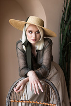 Beautiful Young Blonde Model Is Posing In Straw Hat And Green Transparent Blouse 