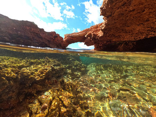  Split underwater photo of exotic island cave with rocky emerald seascape