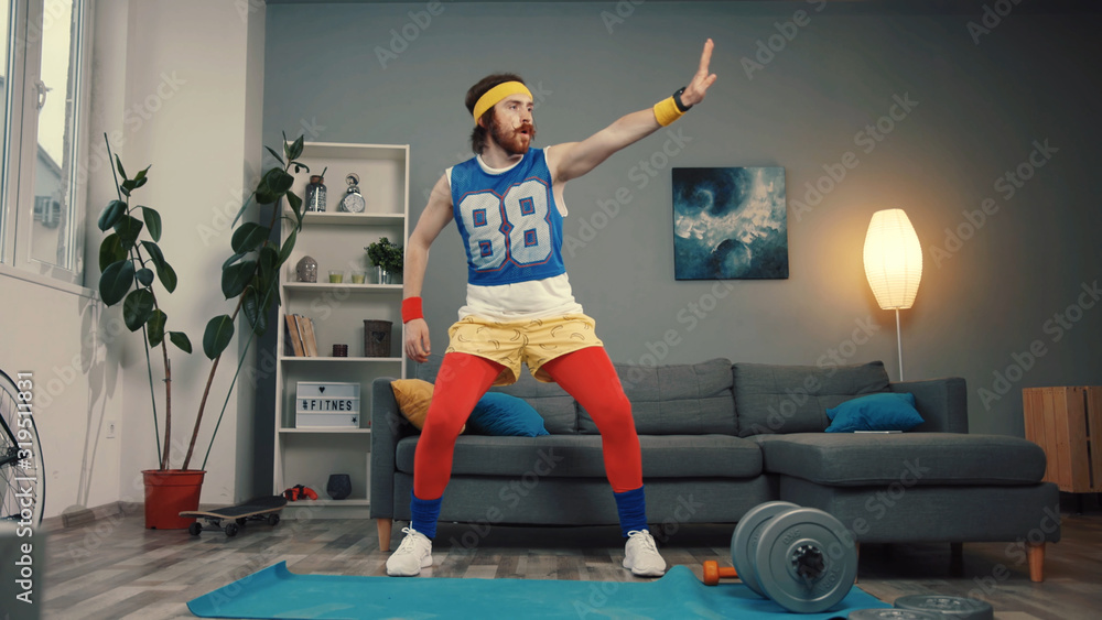 Attractive funny guy in retro sports costume dancing and warming up before hard training. - obrazy, fototapety, plakaty 