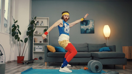 Stupid-looking funny athlete man in retro outfit dancing and warming up having an intense home workout.