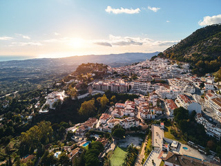 Aerial photo distant view charming Mijas pueblo, typical Andalusian white-washed mountain village, houses rooftops, small town located on hillside Province of Málaga, Costa del Sol, Europe, Spain